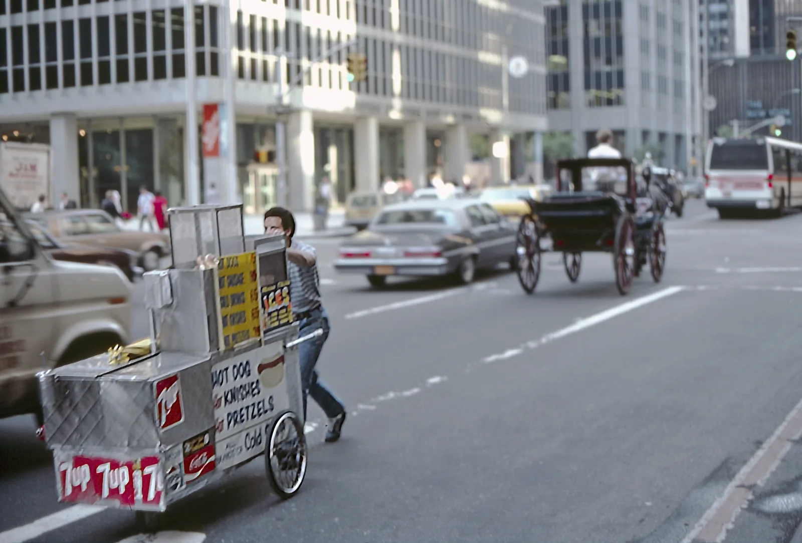 A food cart vendor pushing his cart through midtown Manhattan traffic in 1984